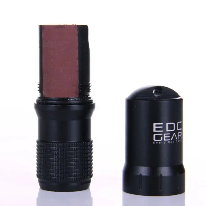 Zwarte EDC capsule geopend met opgerolde inhoud